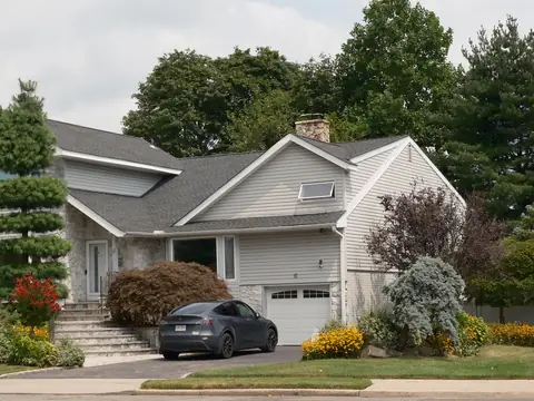 A suburban house with a car in the driveway