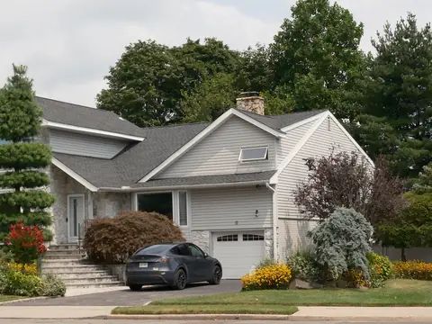 A car parked in the driveway of a suburban house