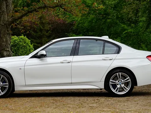 A white sedan parked beside a park